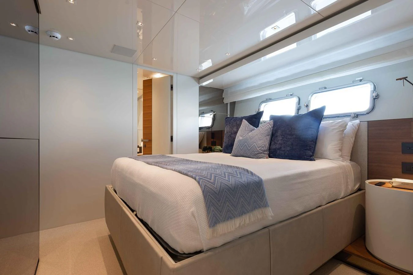 The stateroom features a luxurious bed with plush pillows and ample natural light from the windows. aboard CHAMELEON Yacht for Sale