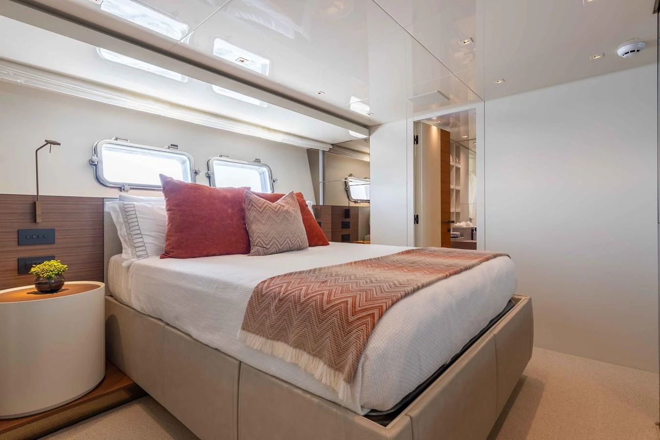 A luxurious stateroom featuring a comfortable bed with stylish bedding and natural light from the windows. aboard CHAMELEON Yacht for Sale