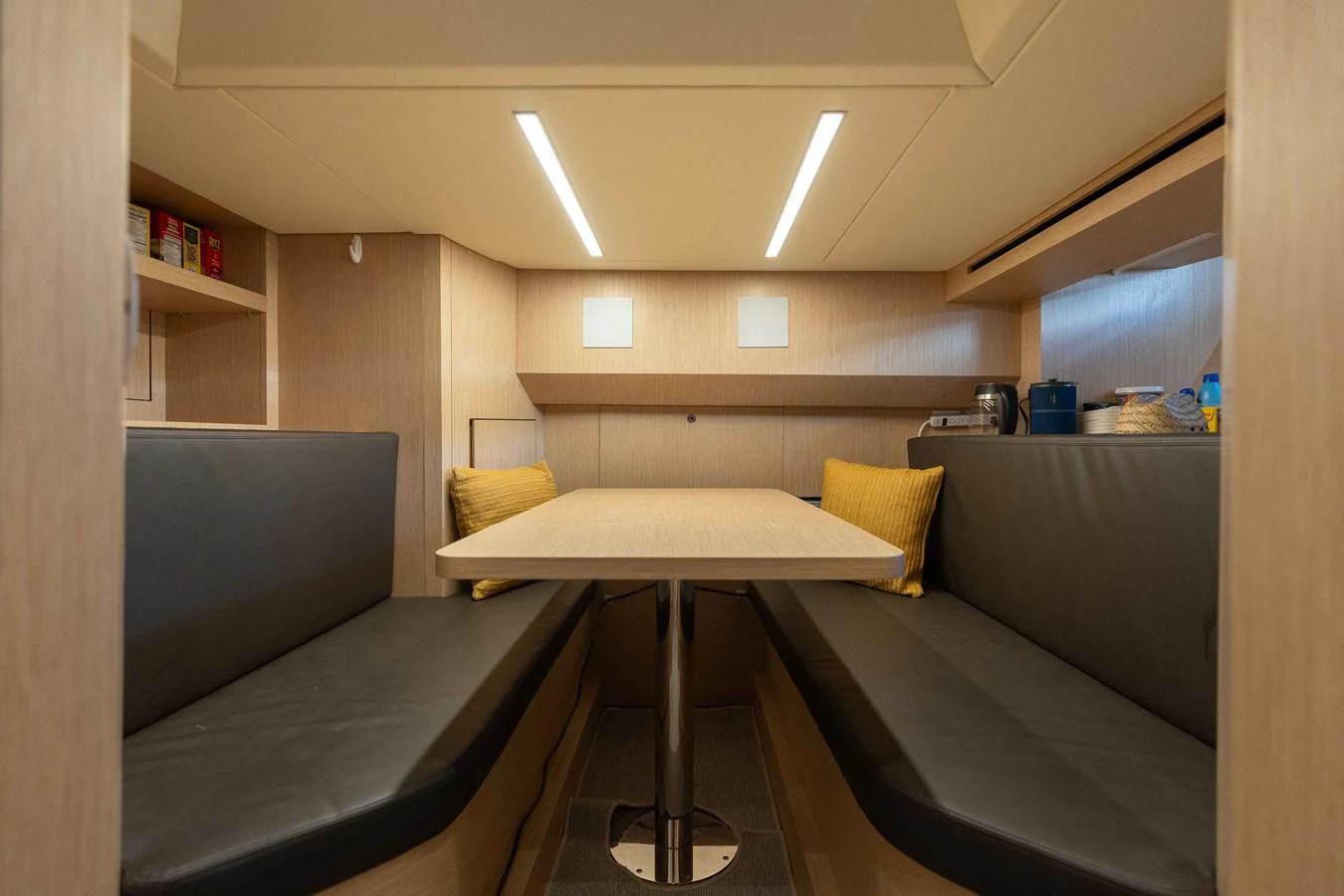 The yacht's dining area features a cozy setup with a wooden table and cushioned seating. aboard CHAMELEON Yacht for Sale