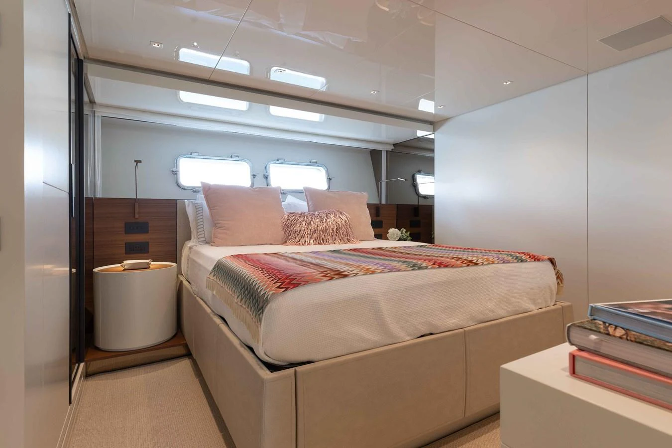 The stateroom features a cozy bed with plush bedding and ample natural light from the windows. aboard CHAMELEON Yacht for Sale