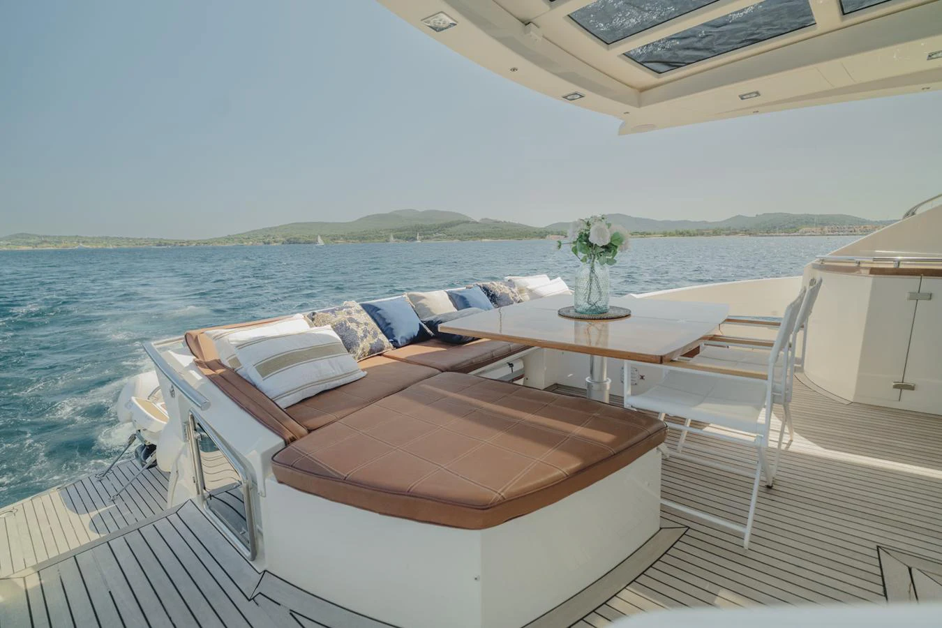 a balcony with a table and chairs on it aboard SCUDERIA Yacht for Sale