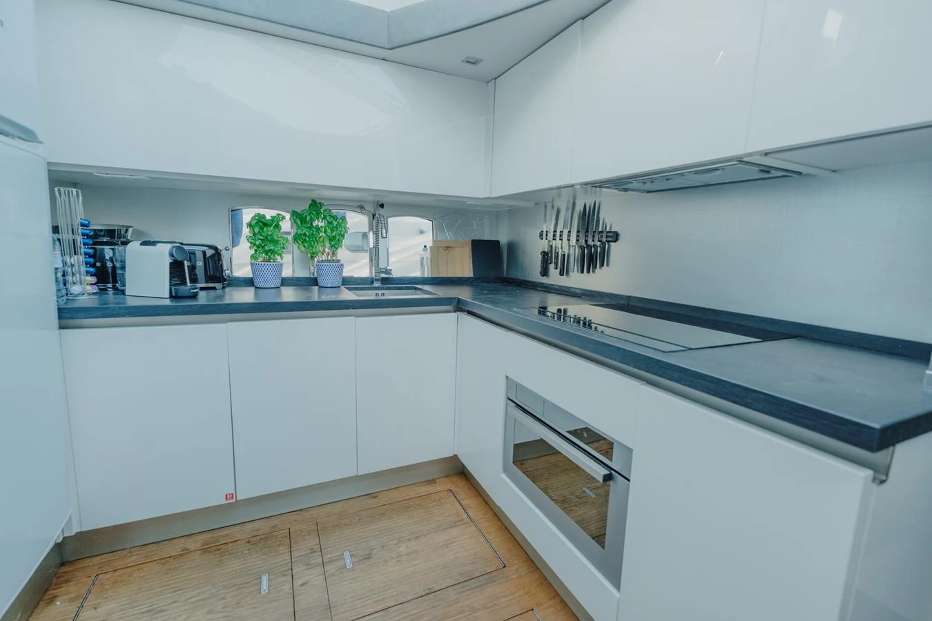 a kitchen with white cabinets aboard SCUDERIA Yacht for Sale