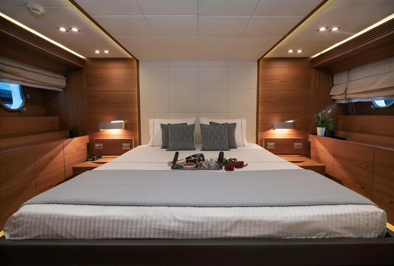 a bed with a white sheet and pillows on it aboard EL PECADO Yacht for Sale