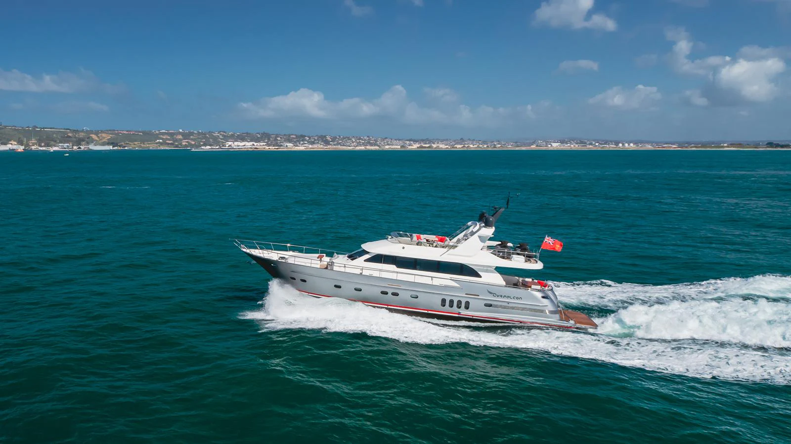 A sleek yacht cruises through clear blue waters under a bright sky. aboard TEST NAME Yacht for Sale