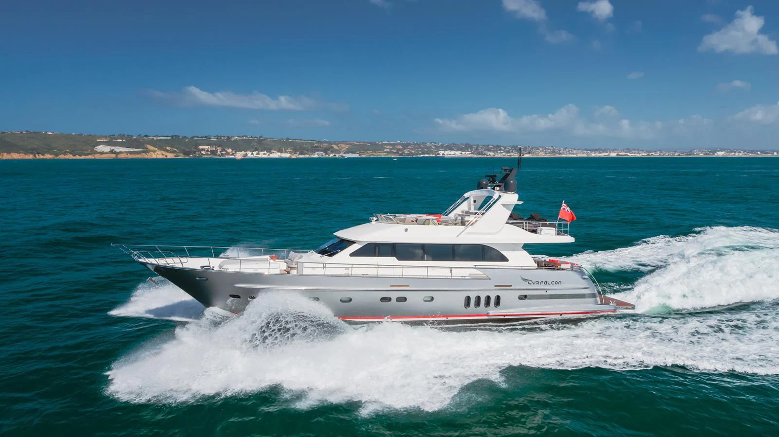 A sleek yacht cruises through vibrant blue waters under a clear sky. aboard TEST NAME Yacht for Sale