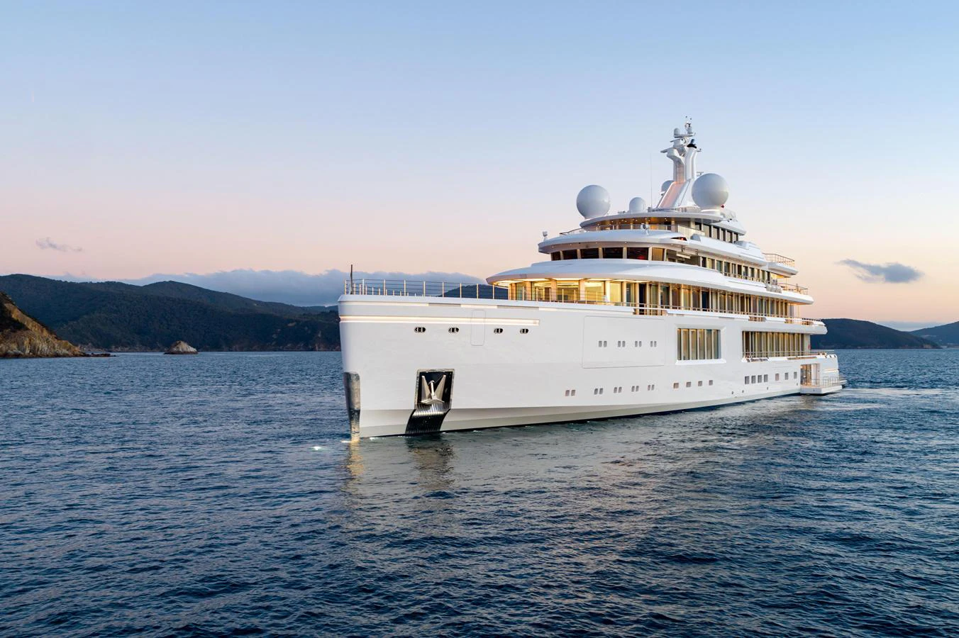 A stunning white yacht glides through calm waters with a scenic coastline in the background. aboard TEST NAME Yacht for Sale