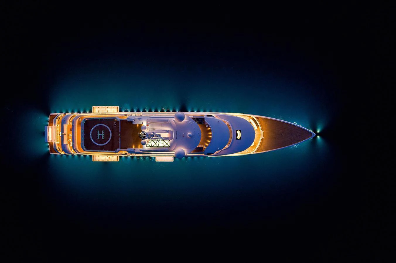 An aerial view of a luxurious yacht illuminated against the dark water. aboard TEST NAME Yacht for Sale