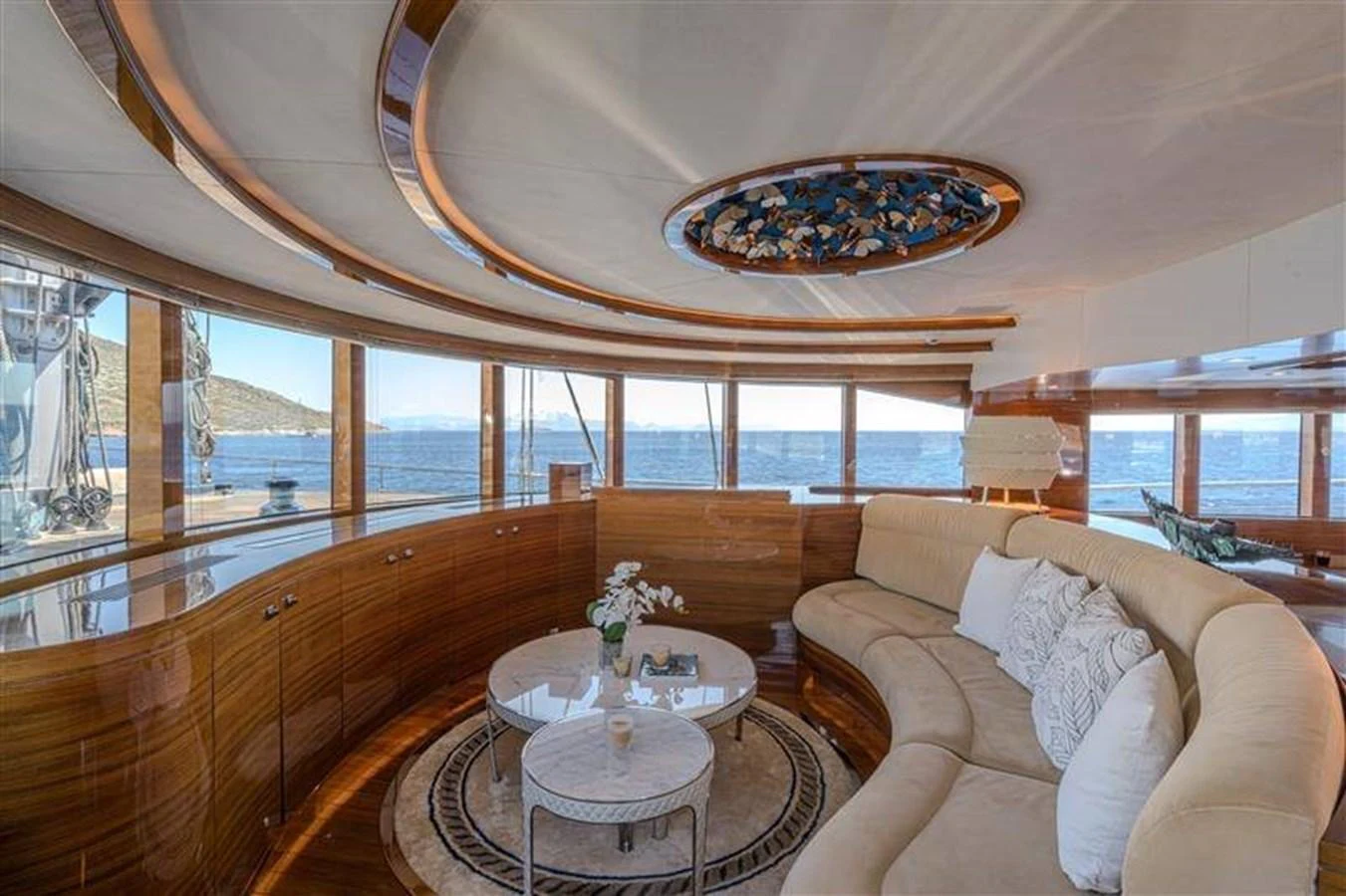 a living room with a large chandelier aboard ATLANTIS PEARL Yacht for Sale