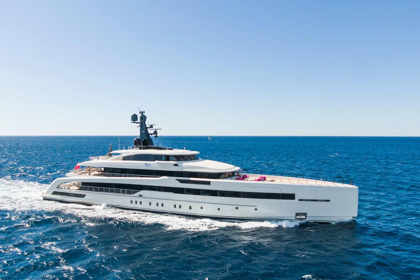 A sleek and modern yacht cruises through the open sea under a clear blue sky. aboard RIO Yacht for Sale