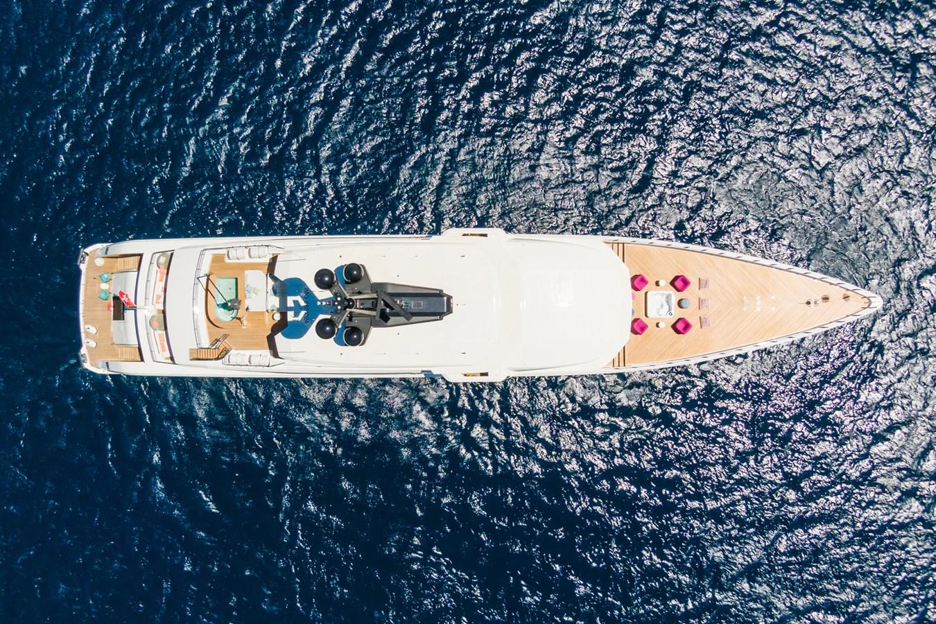 An aerial view of a sleek yacht cruising through deep blue waters, showcasing its luxurious deck and amenities. aboard RIO Yacht for Sale