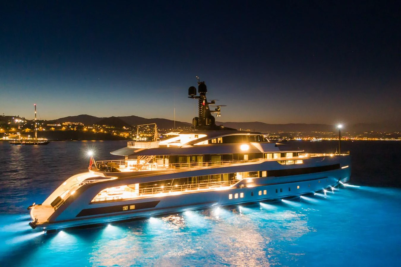 A stunning yacht illuminated at night, showcasing its sleek design and luxurious presence on the water. aboard RIO Yacht for Sale