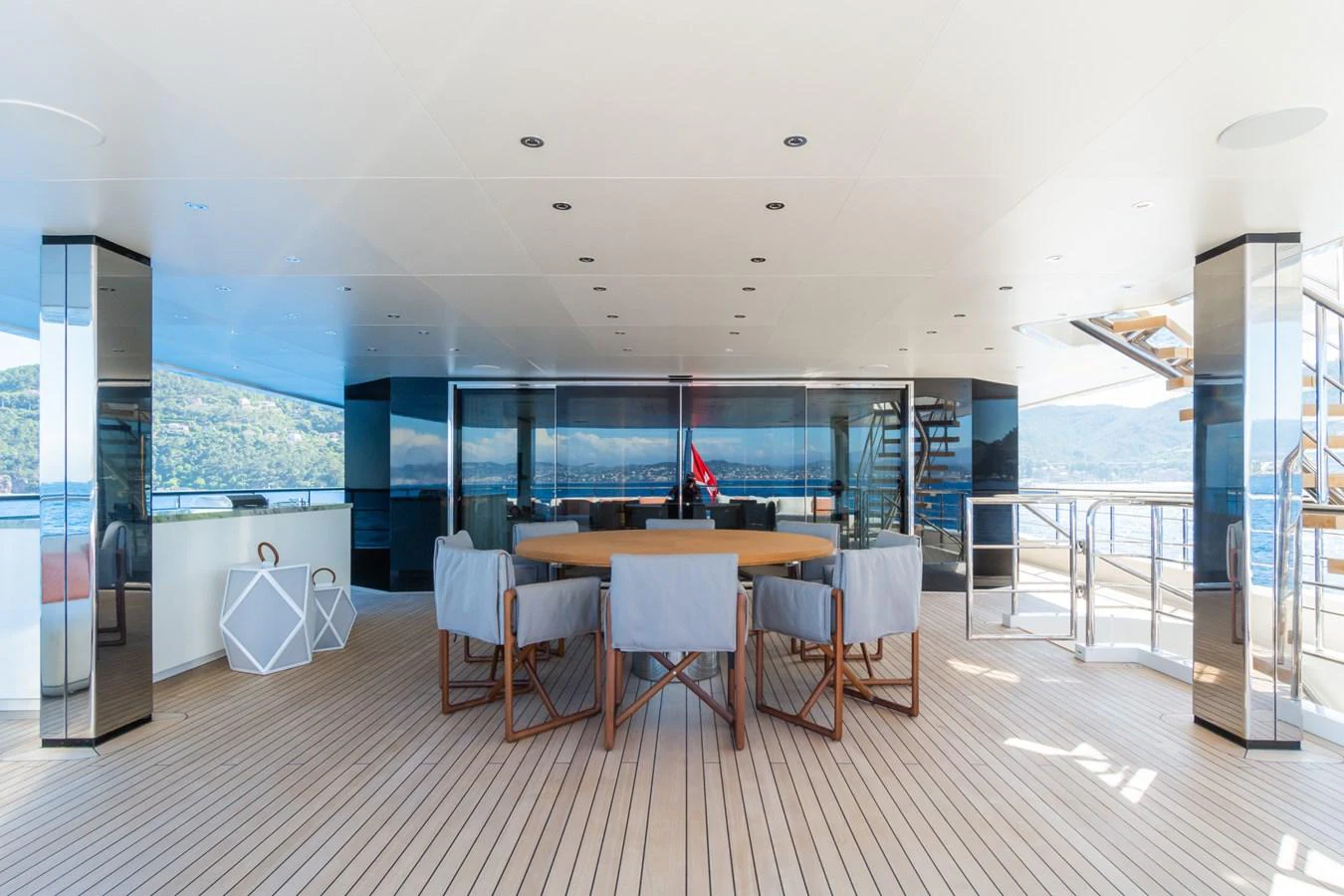 The aft deck features a spacious seating area with a large table, perfect for alfresco dining and relaxation. aboard RIO Yacht for Sale