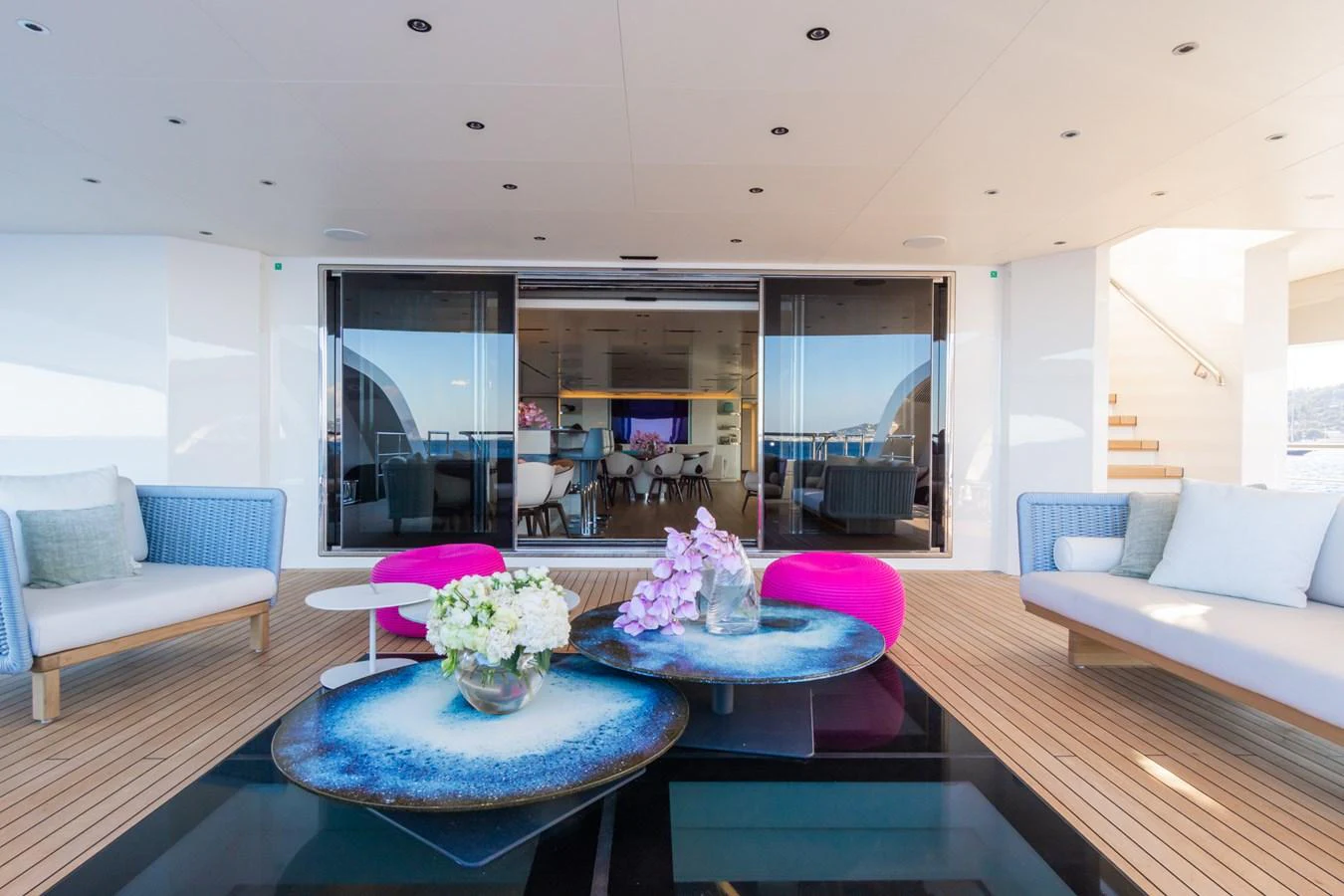The aft deck features a stylish seating area with vibrant accents and a view into the interior lounge. aboard RIO Yacht for Sale