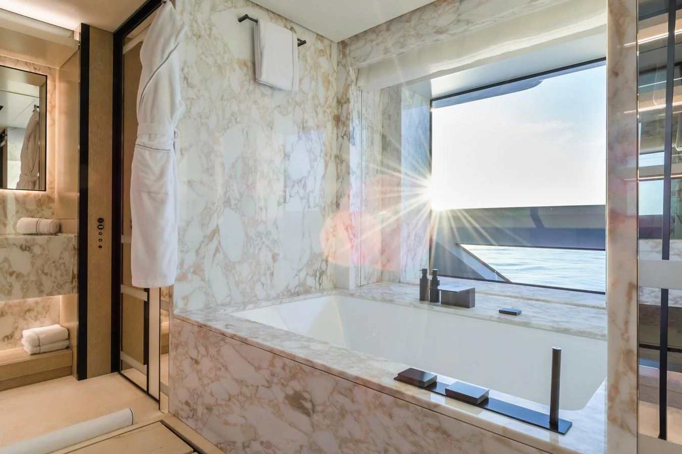 The luxurious bathroom features elegant marble accents and a stunning ocean view. aboard RIO Yacht for Sale
