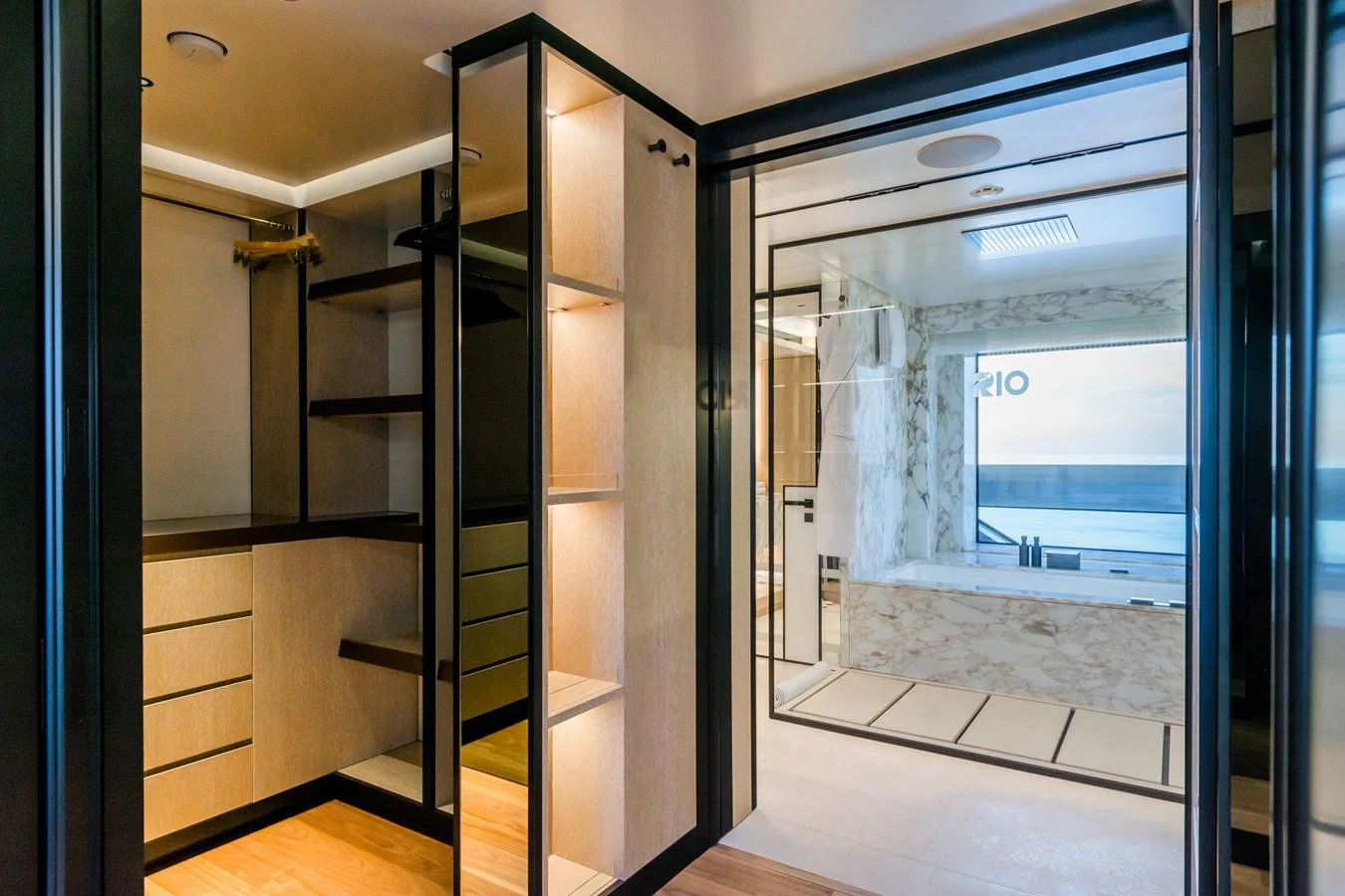 A luxurious bathroom with a walk-in closet and a view of the sea. aboard RIO Yacht for Sale