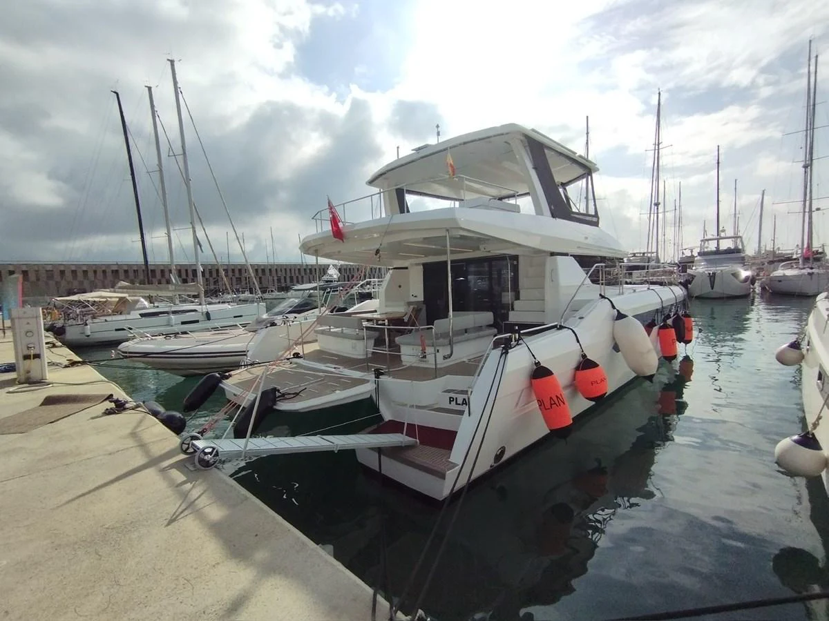 A modern yacht docked at a marina, showcasing its sleek design and spacious aft deck. aboard LEOPARD 28M Yacht for Sale