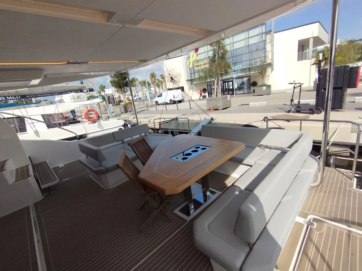 The aft deck features a spacious seating area with a large table, perfect for outdoor dining and relaxation. aboard LEOPARD 28M Yacht for Sale