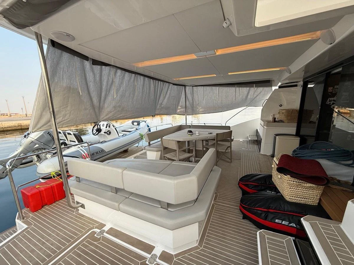 The aft deck features a comfortable seating area with a dining table, perfect for outdoor relaxation and dining. aboard LEOPARD 28M Yacht for Sale