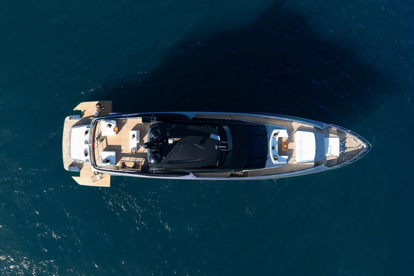 A sleek and modern yacht is captured from an aerial perspective, showcasing its elegant design and spacious deck areas. aboard RIVA 112 DOLCEVITA SUPER Yacht for Sale