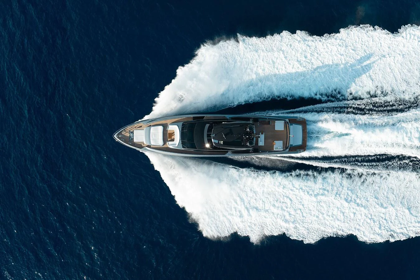 A sleek yacht cuts through the deep blue water, leaving a trail of white foam in its wake. aboard RIVA 112 DOLCEVITA SUPER Yacht for Sale