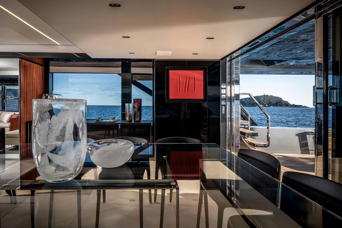 The yacht's interior features a sophisticated dining area with a stunning ocean view through large windows. aboard RIVA 112 DOLCEVITA SUPER Yacht for Sale
