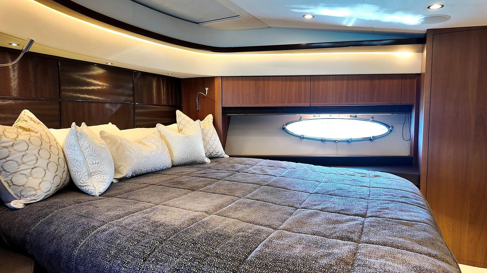 The stateroom features a plush bed with elegant bedding and a stylish porthole window. aboard GIA GIA' Yacht for Sale