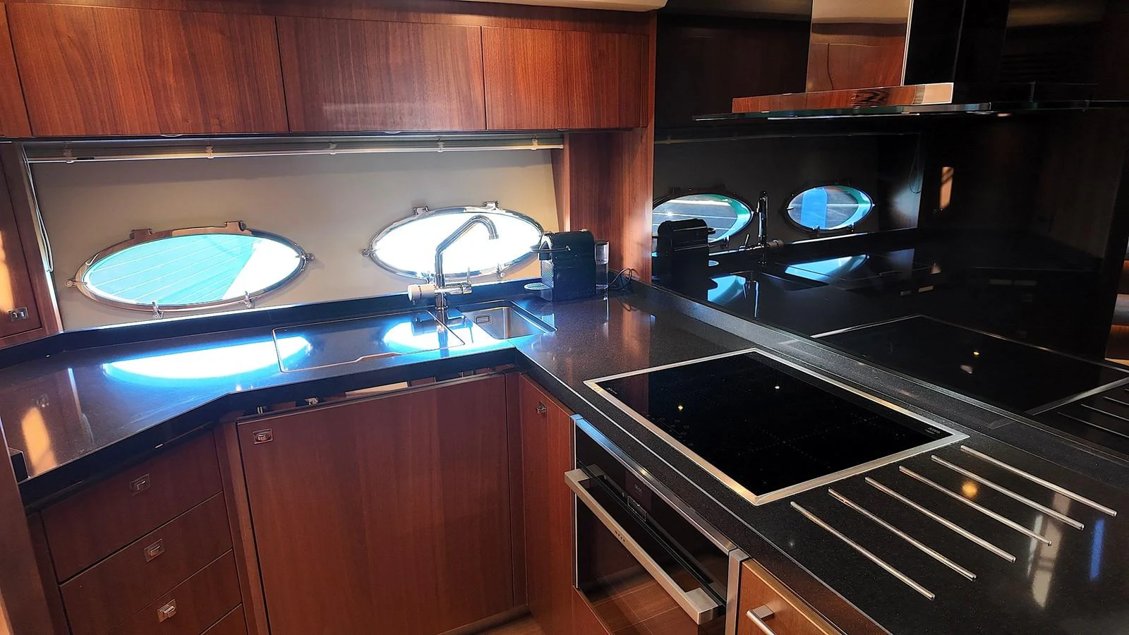 The yacht's galley features sleek countertops, modern appliances, and ample natural light through porthole windows. aboard GIA GIA' Yacht for Sale