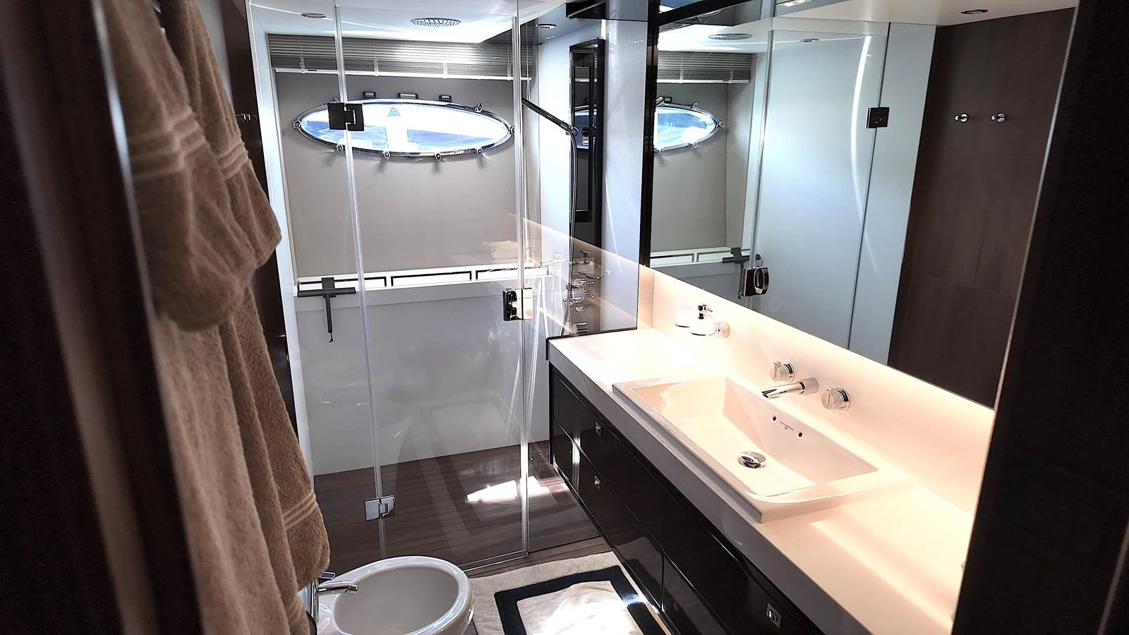 The yacht's bathroom features modern fixtures and a sleek design, highlighted by natural light from the porthole. aboard GIA GIA' Yacht for Sale