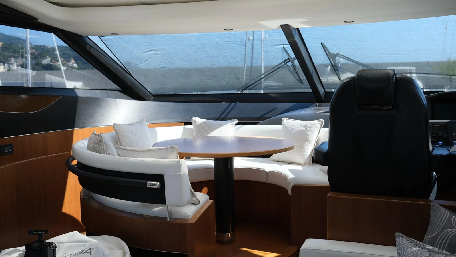 The yacht's saloon features a cozy seating area with a round table and large windows offering scenic views. aboard GIA GIA' Yacht for Sale