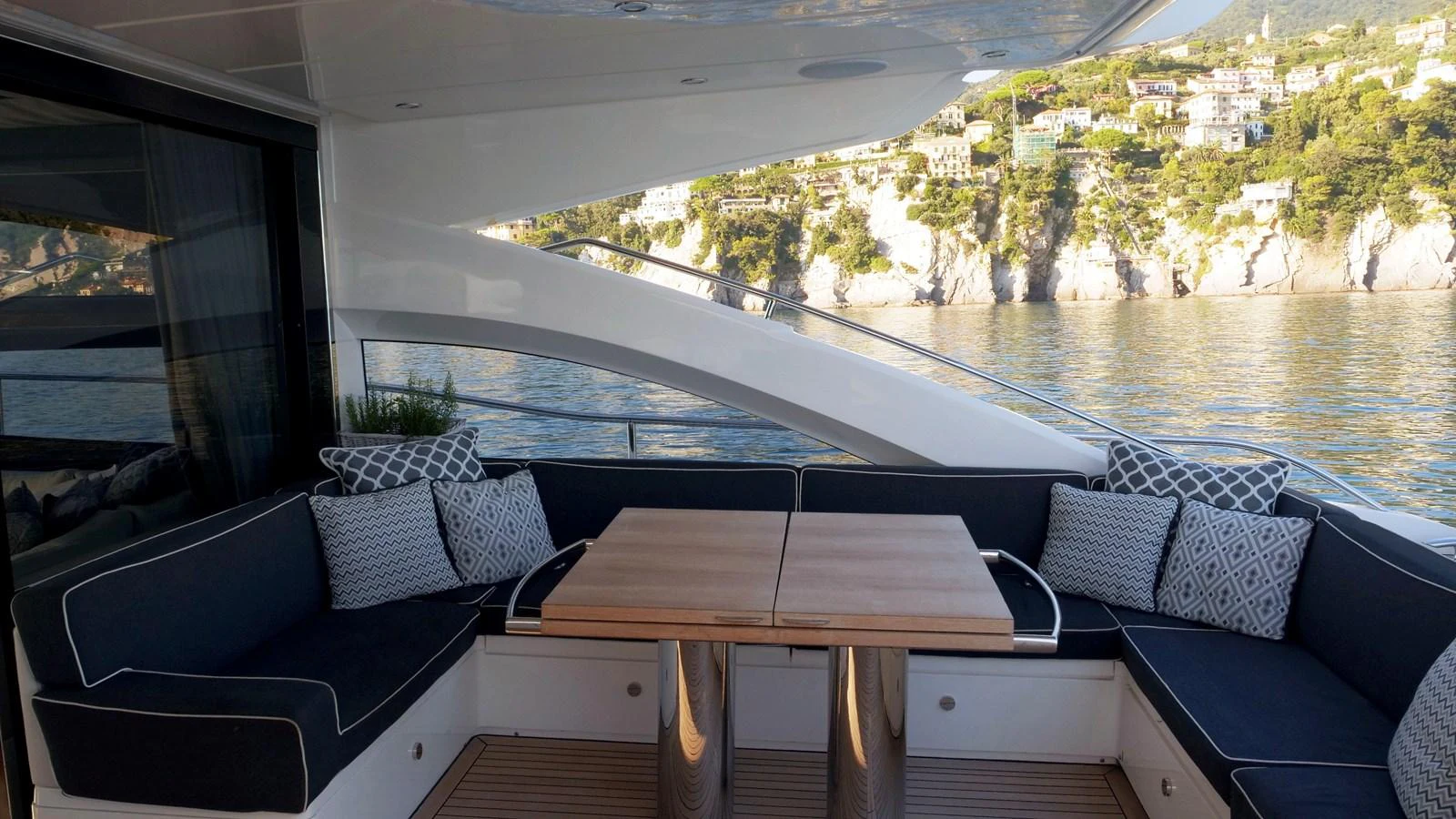 The aft deck features a stylish seating area with a wooden table, offering a perfect spot for relaxation and enjoying the view. aboard GIA GIA' Yacht for Sale