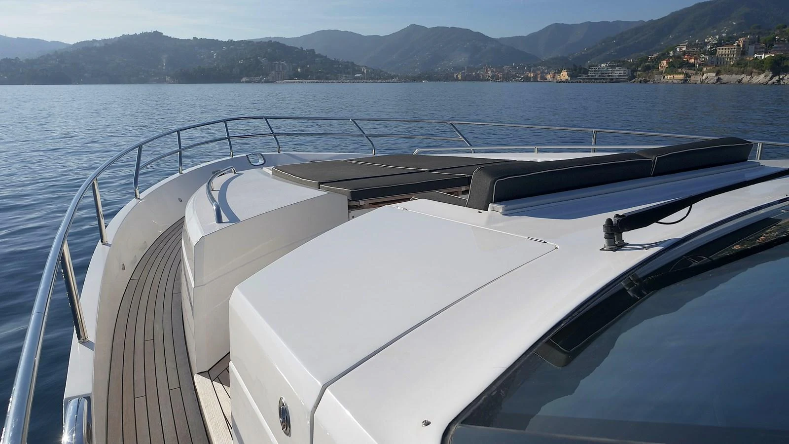 The yacht's sleek exterior deck offers a stunning view of the surrounding coastline and mountains. aboard GIA GIA' Yacht for Sale