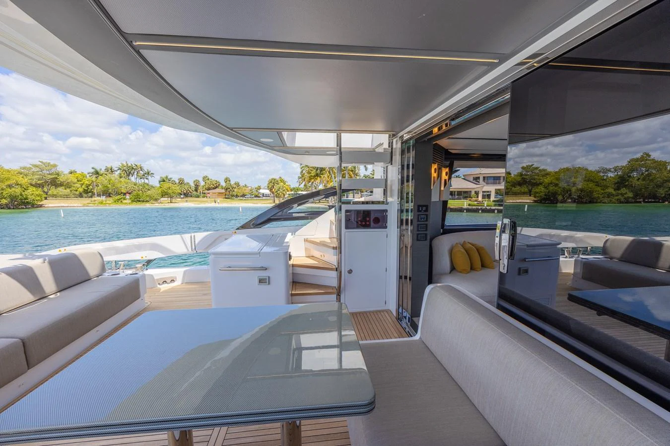The aft deck features a comfortable seating area with a dining table, offering a seamless transition to the outdoors. aboard NO TIME TO DIE Yacht for Sale
