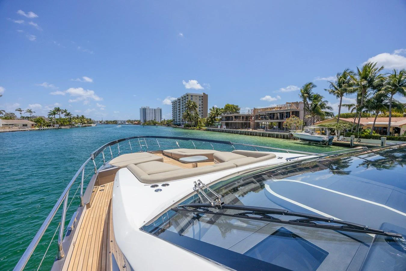 The yacht's foredeck offers a luxurious sunbathing area with plush cushions and a stunning view of the surrounding water and shoreline. aboard NO TIME TO DIE Yacht for Sale