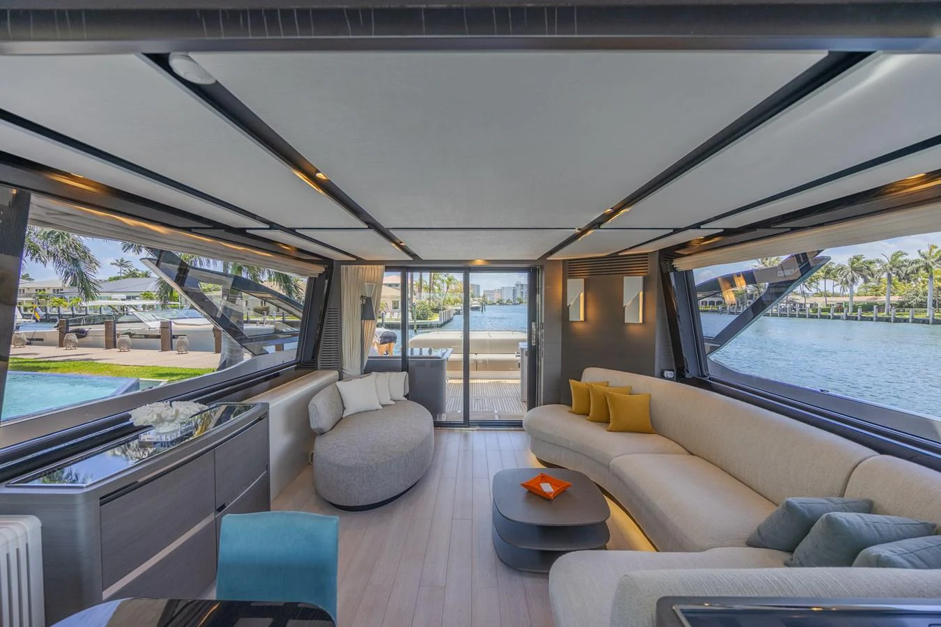 The salon features modern furnishings with large windows offering panoramic views. aboard NO TIME TO DIE Yacht for Sale