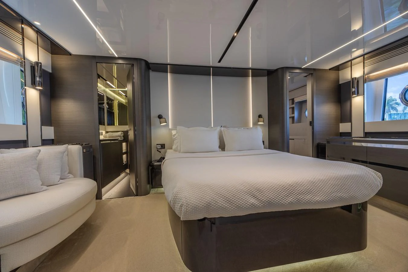 The master stateroom features a luxurious bed with modern lighting and sleek furnishings. aboard NO TIME TO DIE Yacht for Sale