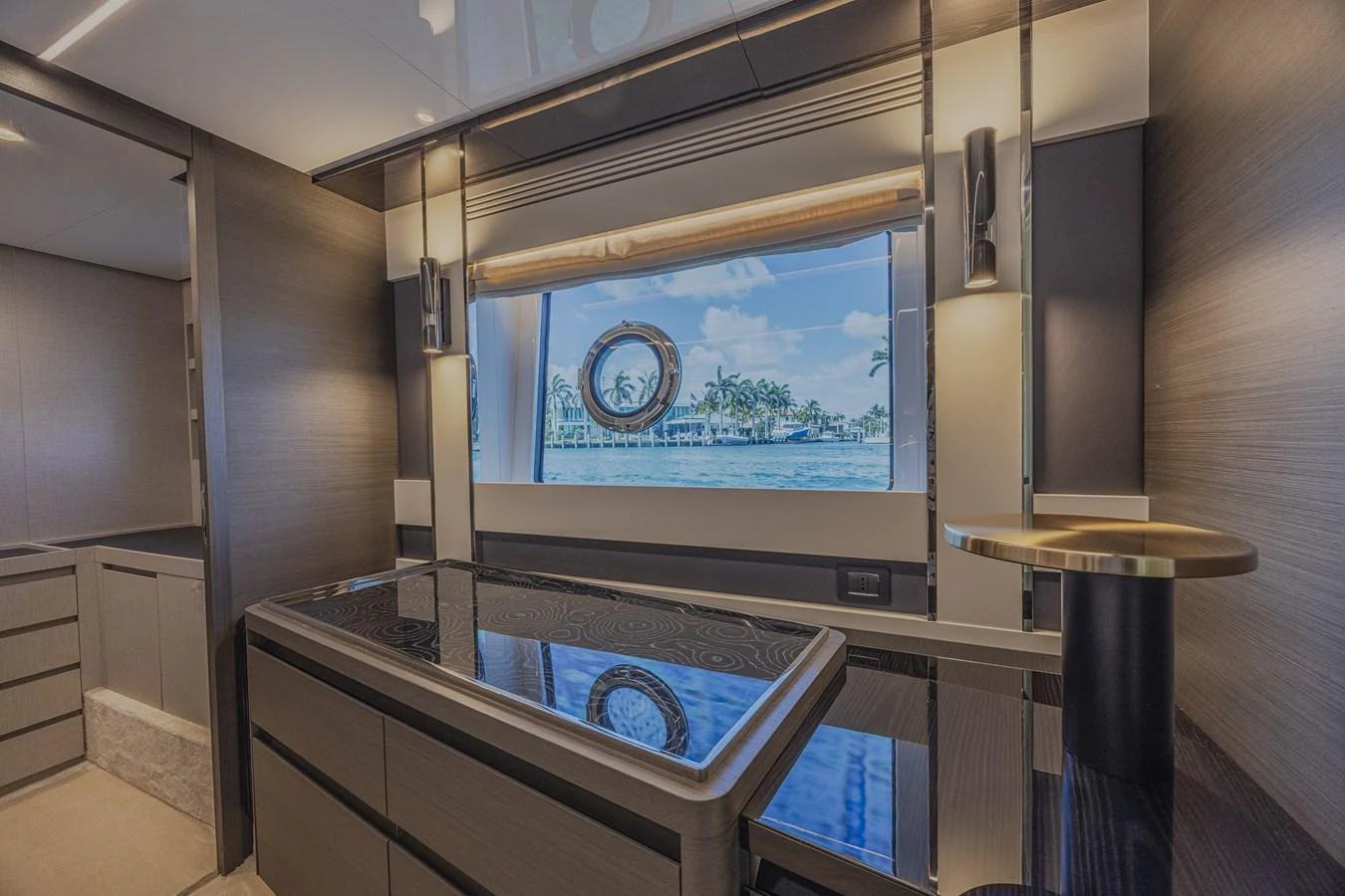 The yacht's interior features a sleek, modern design with a large window offering a scenic view of the water. aboard NO TIME TO DIE Yacht for Sale