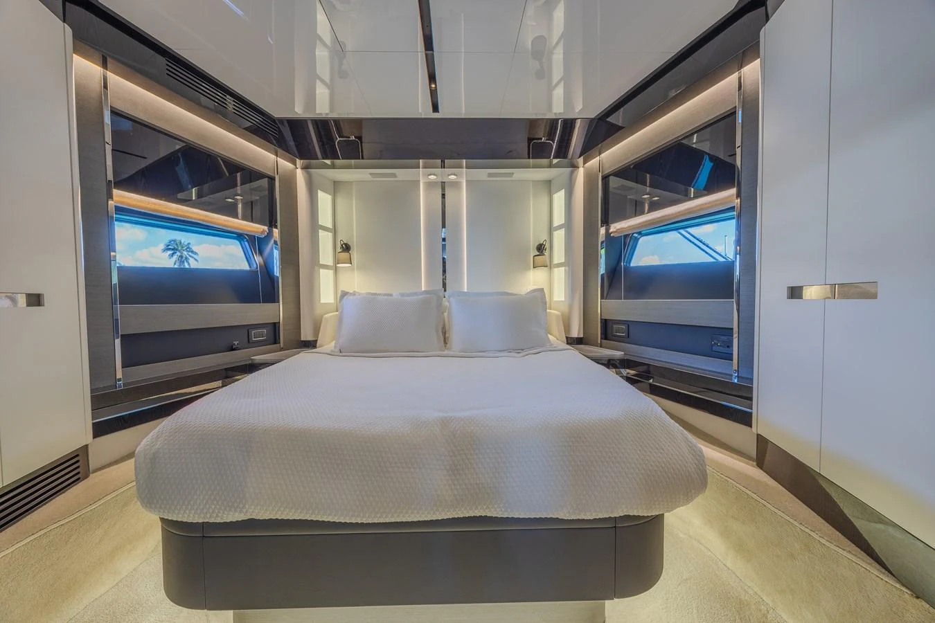 The stateroom features a luxurious bed with modern lighting and sleek design elements. aboard NO TIME TO DIE Yacht for Sale