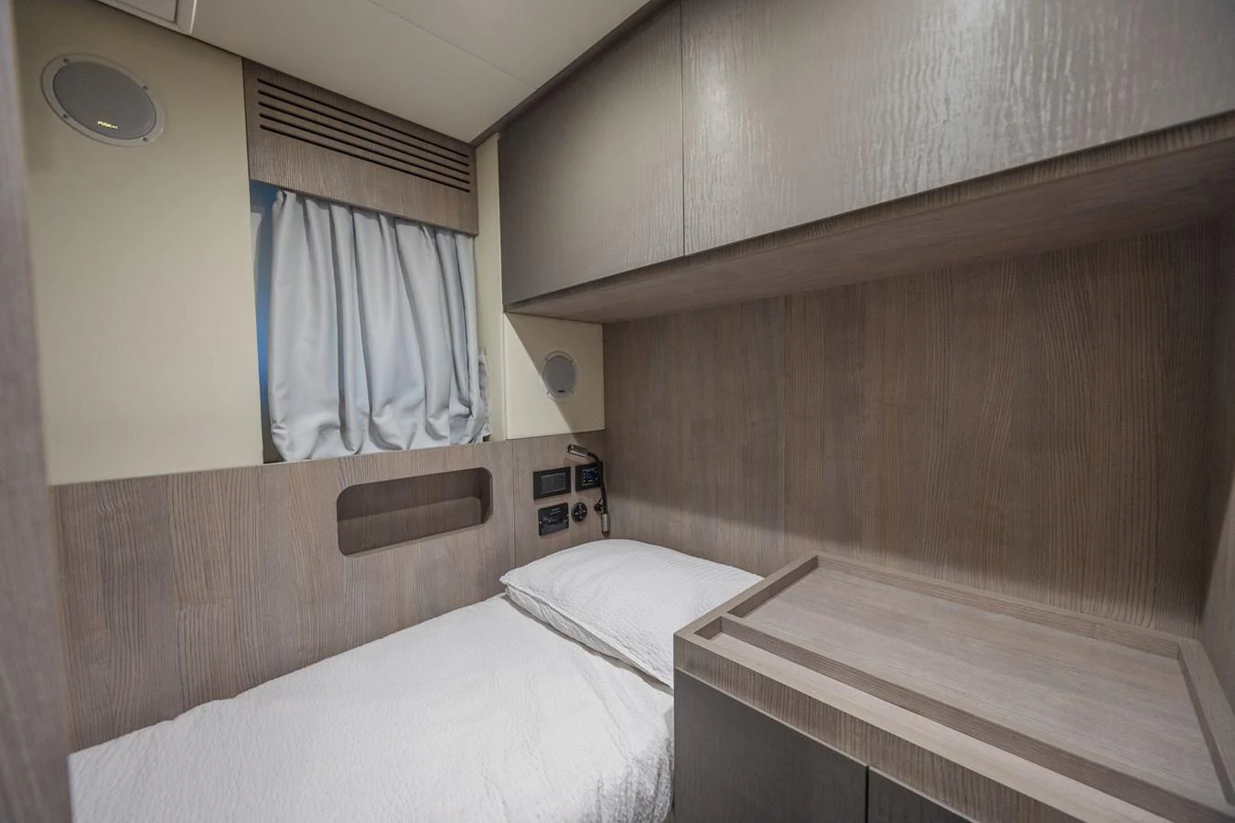 A cozy cabin with a single bed and modern wooden finishes. aboard NO TIME TO DIE Yacht for Sale