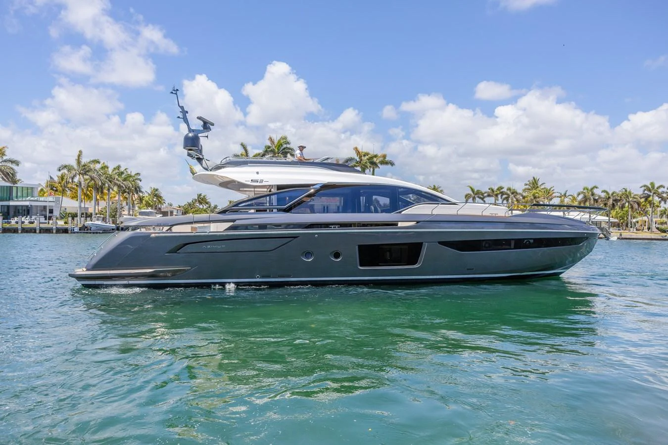 A sleek and modern yacht glides gracefully on calm waters under a bright blue sky. aboard NO TIME TO DIE Yacht for Sale