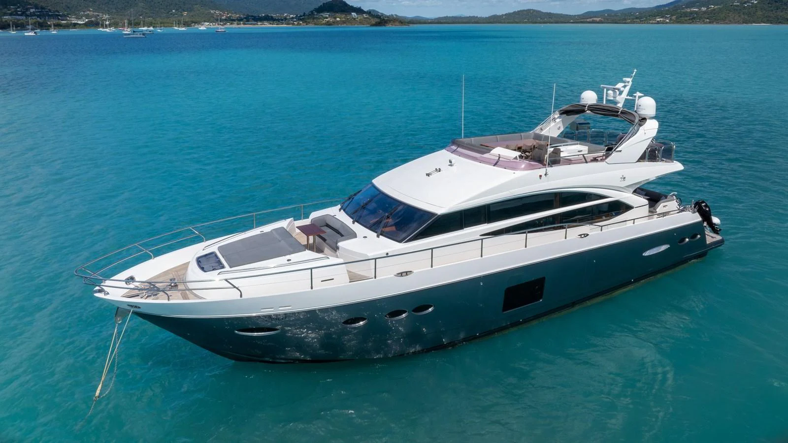 A sleek and modern yacht glides gracefully on turquoise waters, showcasing its elegant design. aboard ABOUT TIME Yacht for Sale
