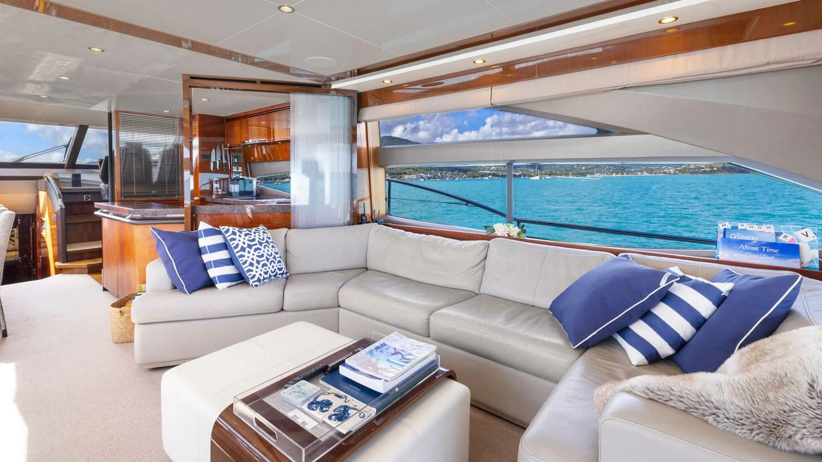 The salon features a spacious seating area with large windows offering stunning ocean views. aboard ABOUT TIME Yacht for Sale