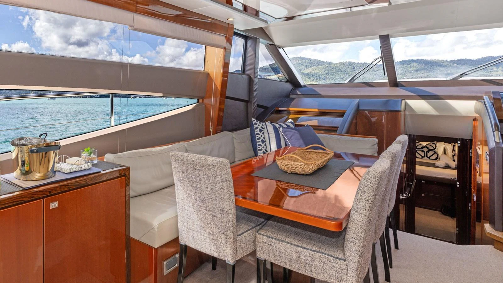 The yacht's dining area features a sleek table with comfortable seating and panoramic windows offering stunning views. aboard ABOUT TIME Yacht for Sale