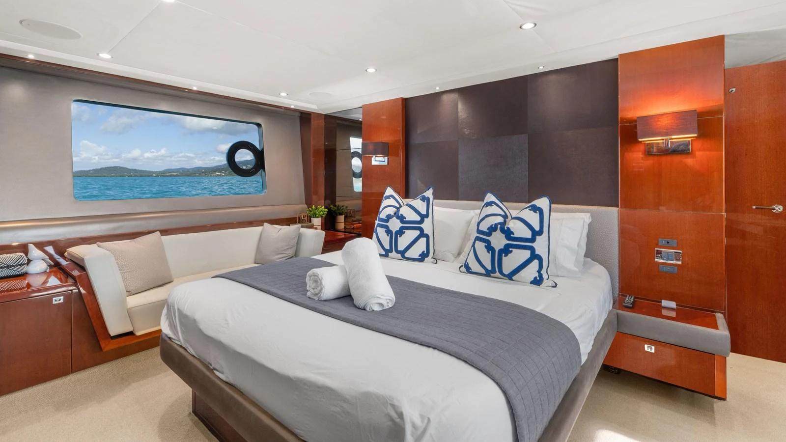 The master stateroom features a luxurious bed with elegant decor and a scenic view through the window. aboard ABOUT TIME Yacht for Sale
