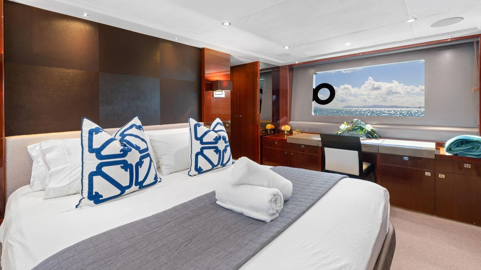 The master stateroom features a luxurious bed with elegant decor and a scenic ocean view. aboard ABOUT TIME Yacht for Sale