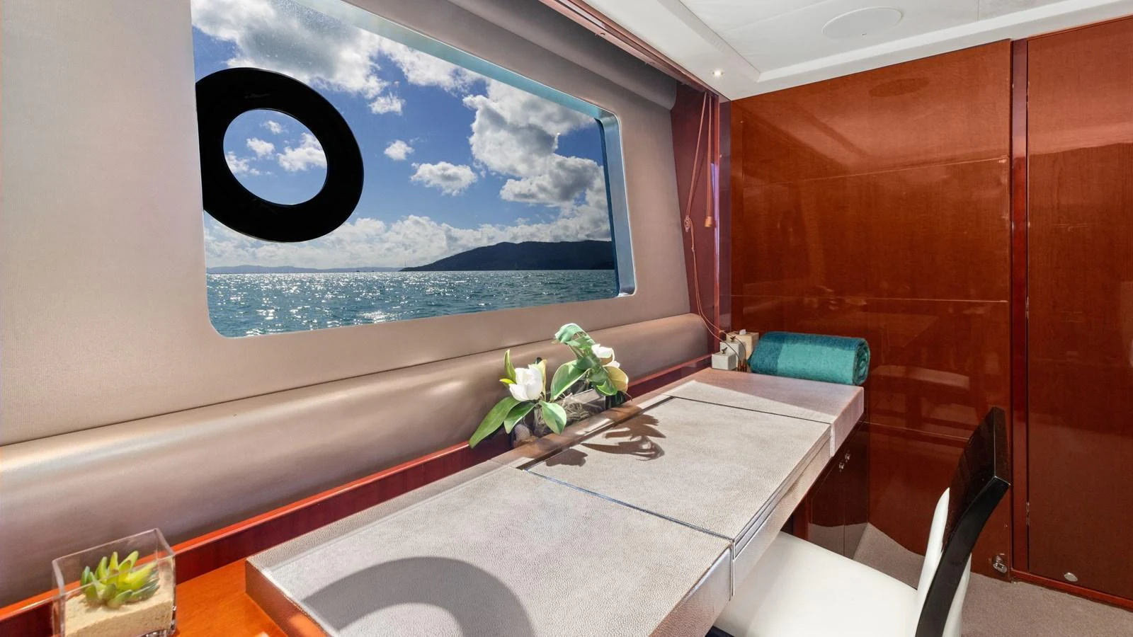A stylish dining area with a scenic ocean view through the window. aboard ABOUT TIME Yacht for Sale
