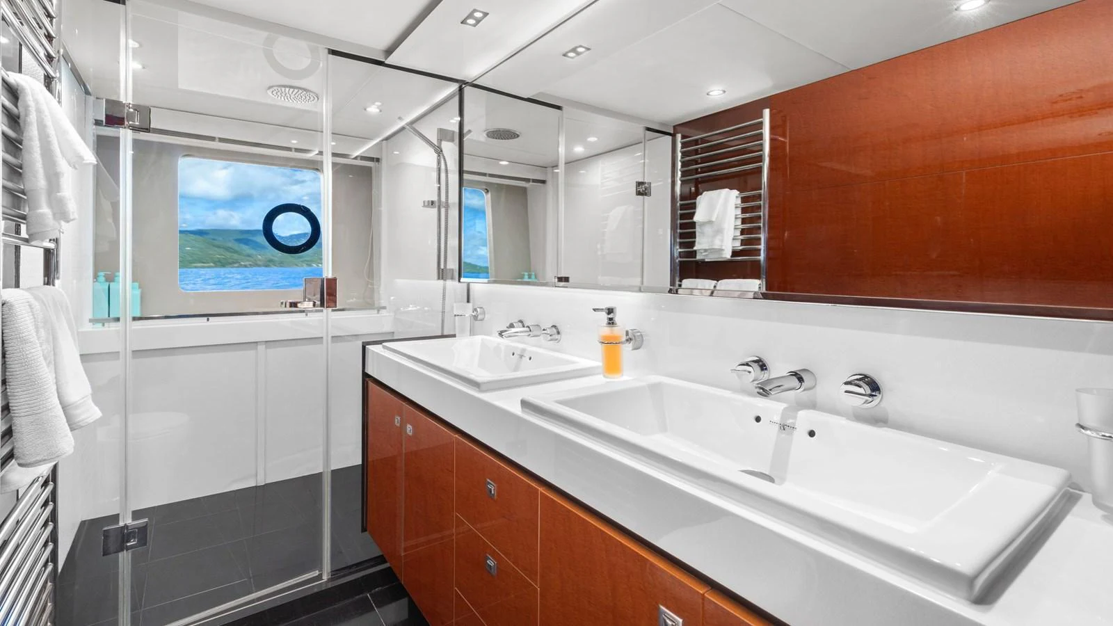The yacht's bathroom features a modern design with dual sinks and a spacious shower area. aboard ABOUT TIME Yacht for Sale
