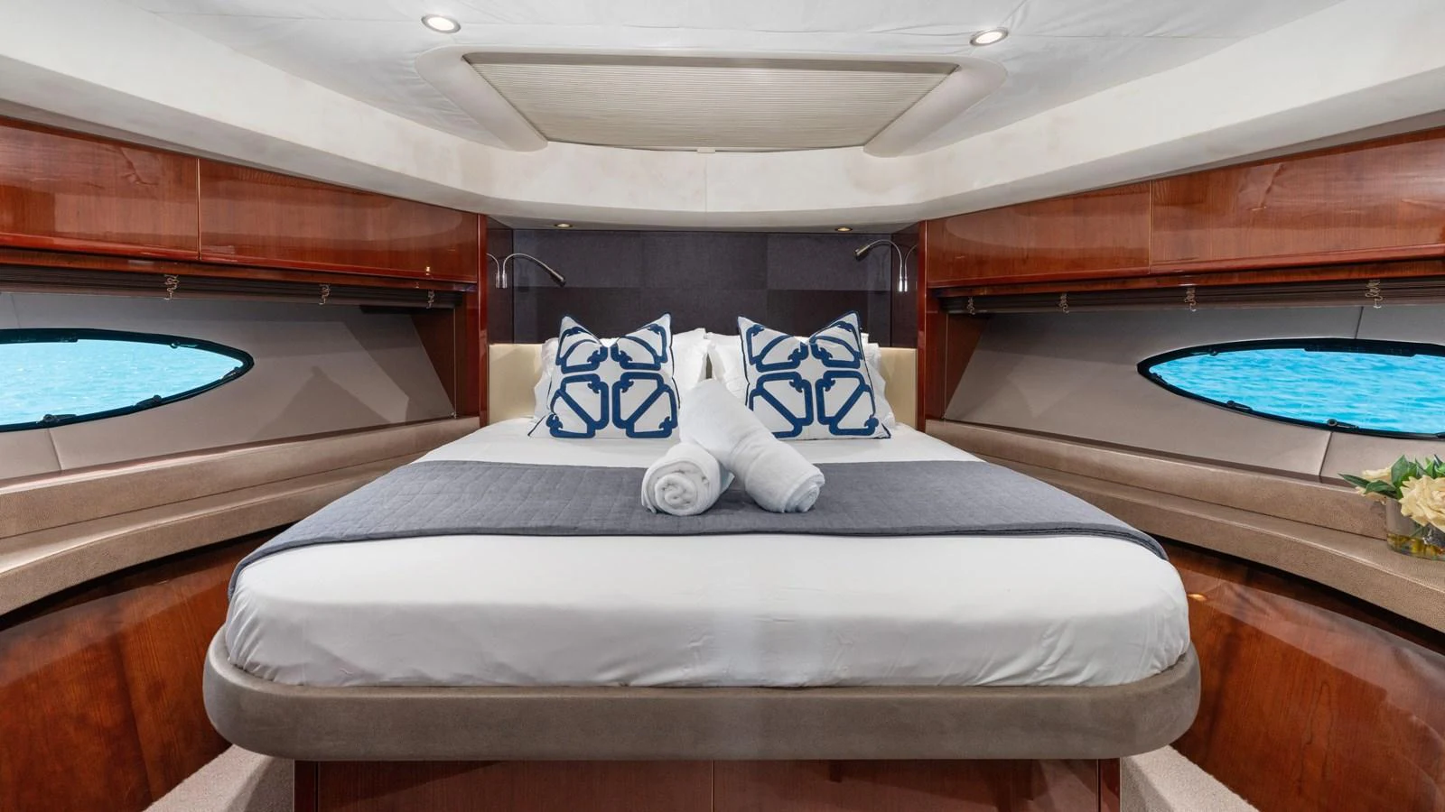A luxurious stateroom featuring a large bed with elegant bedding and ample natural light from the windows. aboard ABOUT TIME Yacht for Sale