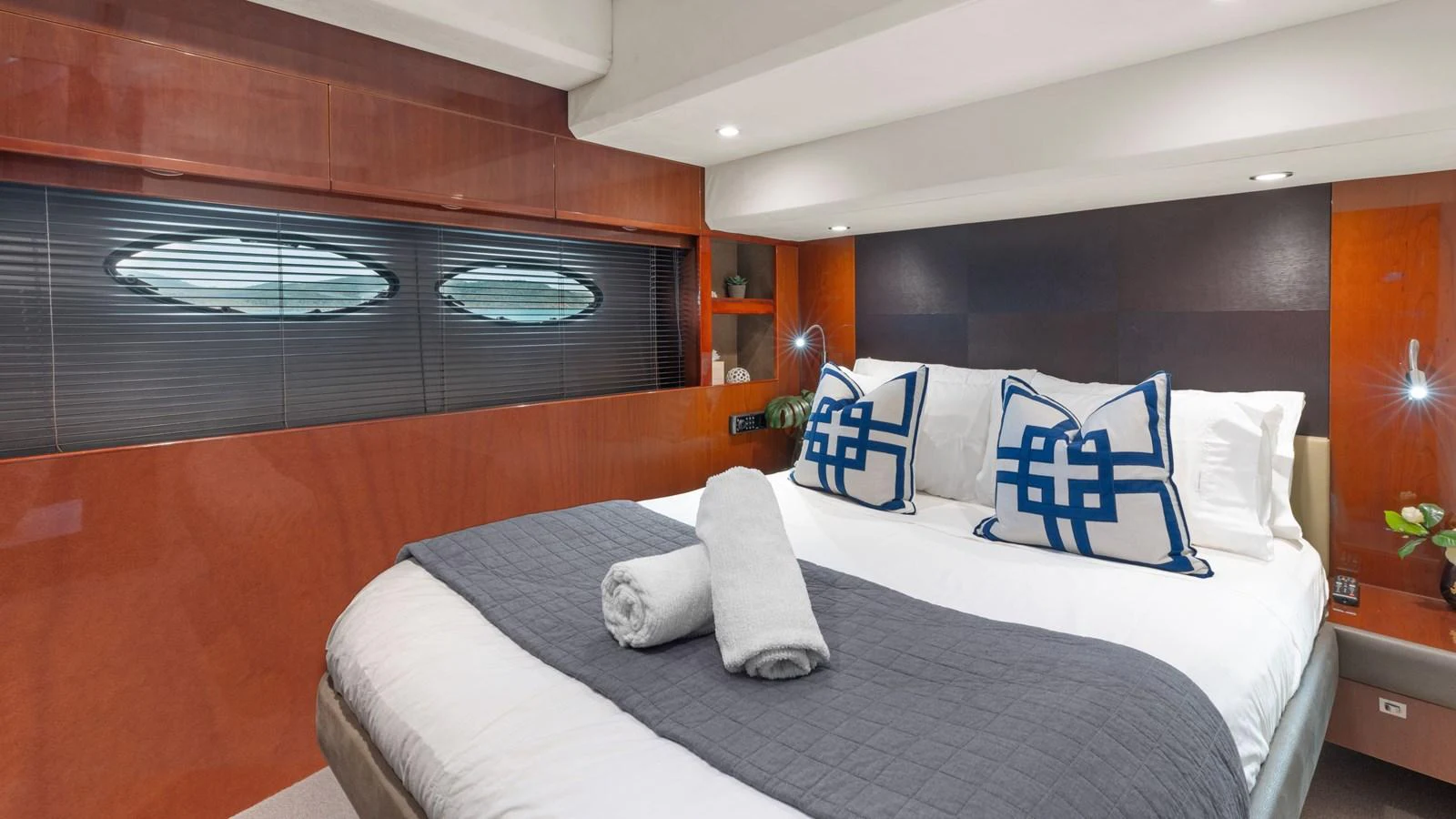 The stateroom features a luxurious bed with elegant decor and ample natural light. aboard ABOUT TIME Yacht for Sale