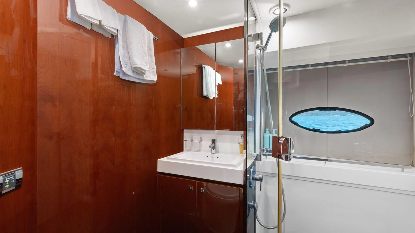 The yacht's bathroom features a sleek design with a glass-enclosed shower and a modern vanity. aboard ABOUT TIME Yacht for Sale