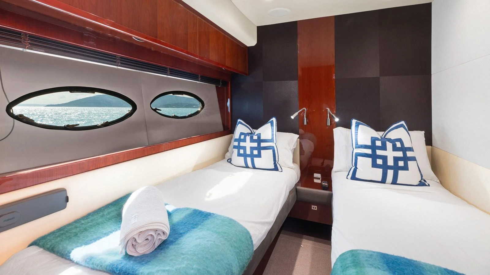The twin stateroom features two single beds with elegant bedding and a view of the sea through the portholes. aboard ABOUT TIME Yacht for Sale